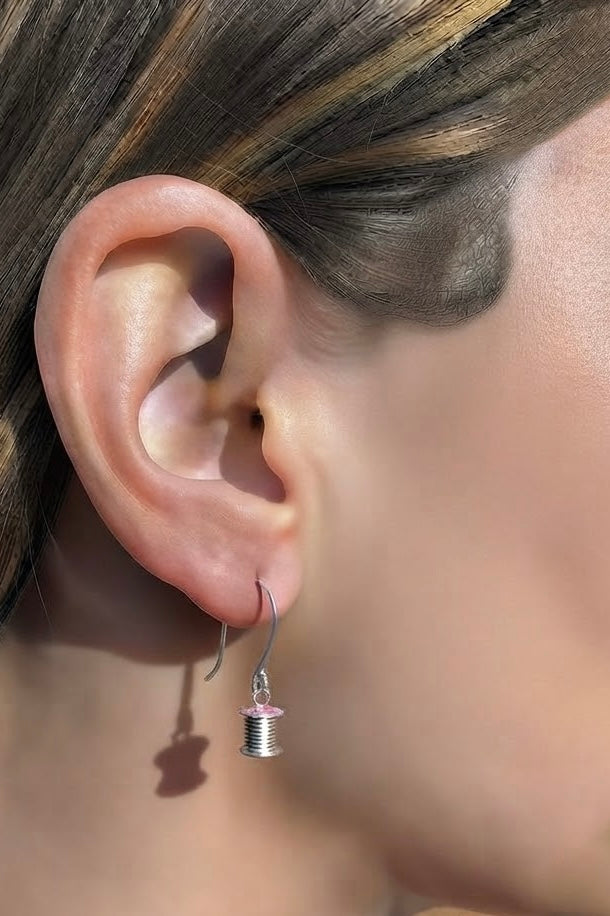 Image of lady wearing a cotton reel earring